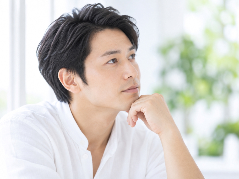 髪について考える男性